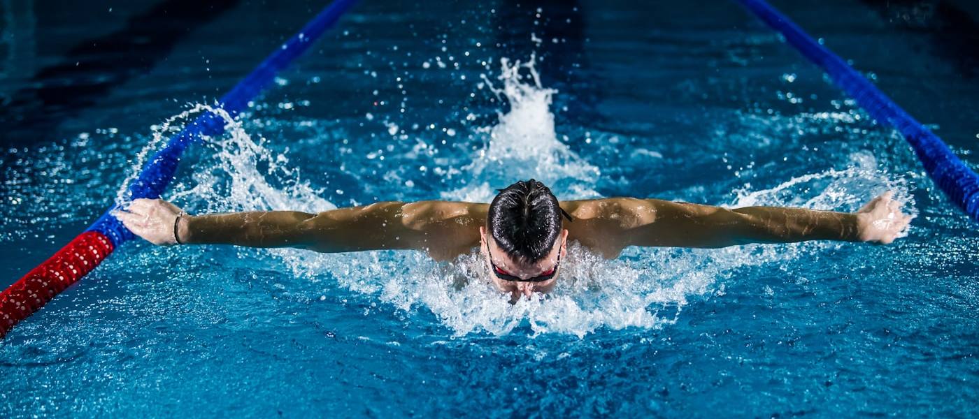 Swimmer mid-stroke in clear blue water