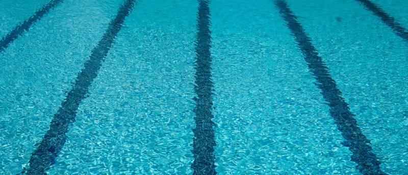 Crystal-clear blue pool water with lane lines